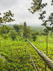 A long zipline cable stretches into the distance over a lush green valley in Costa Rica.
