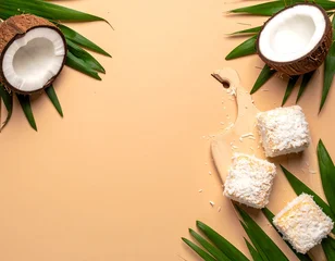 Fototapete Badezimmer Coconut treats on pastel background with palm leaves  © Malika
