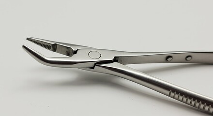 Obraz premium Gleaming Stainless Steel Dental Pliers - Precision Instrument on Clean White Backdrop.