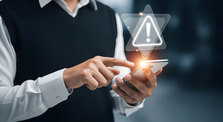 Businessperson using smartphone with warning alert icon in a modern office environment for technology security and digital communication concepts