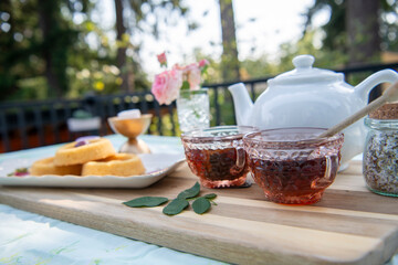 Two pink glass cups filled with tea for an al fresco tea party picnic.