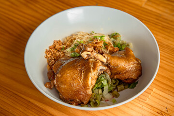 Delectable Braised Pork Leg Noodle: A close-up shot of a steaming bowl, the star being the rich, tender braised pork leg resting amidst noodles and fresh vegetables, a culinary delight.