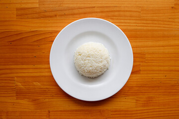 Steaming Rice on a Plate: A simple yet appealing shot of a perfectly cooked portion of fluffy rice, presented on a clean, elegant white plate. The food photography highlights the textures.