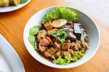Braised Pork and Tofu in Gravy: A top-down shot of a dish with a medley of tender pork belly, tofu cubes, and a perfectly boiled egg, all nestled in a rich, savory gravy.