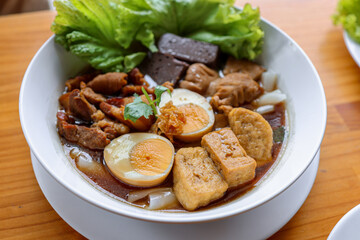 Culinary Symphony: A close-up shot of a delectable bowl of Asian cuisine, showcasing an artful arrangement of textures and flavors, enticing the viewer with its authentic visual appeal.