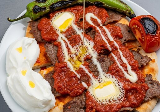 Delicious Iskender Kebab with melted butter, tomato, yogurt, and pepper
