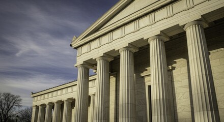 Majestic Neoclassical Building with Fluted Stone Columns under a Cloudy Blue Sky, Bathed in Golden Sunlight, Showcasing Grand Architectural Details and Shadows.