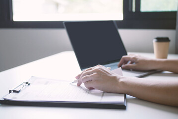 Young businesswoman holding resume and evaluating. Reviewing profile of job applicants to find new candidates to work together. Recruitment concept