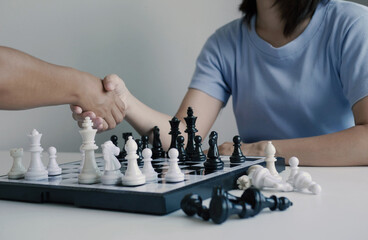 Two Asian women are agreeing to play chess. Business management competition and risk management is...