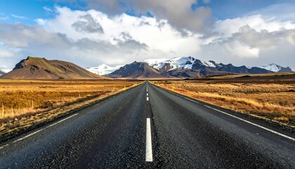 A vast, paved highway stretches into a landscape of dramatic mountains under a dramatic sky, showcasing the beauty of open roads.