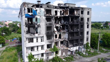 Devastated, multi-story residential building with severe fire damage, charred surfaces, and collapsed sections, reflecting a scene of conflict in a town