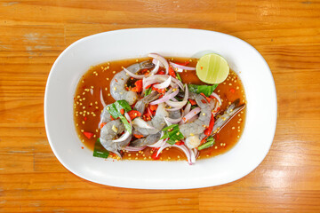 Seafood Delights: A beautifully presented plate of raw shrimp salad, bursting with fresh ingredients and enticing flavors, a culinary creation designed to excite the taste buds.