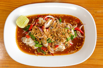 Spicy Seafood Salad: A vibrant and tantalizing seafood salad, bursting with fresh flavors and an appealing presentation, is served on a pristine white plate.