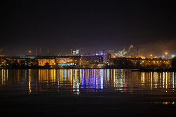 Reflection of the city at night in the waters of the river
