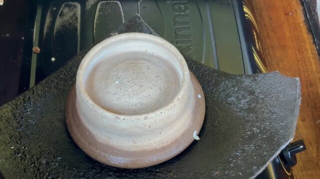 The process of making "Surabi" cake using a special pan and covered with clay pottery.