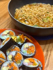 Kimbap and Ramyun, a perfect Korean combo! Enjoy savory rice rolls with vegetables, meat, and pickles alongside a flavorful bowl of spicy, comforting ramen. A satisfying meal for any time of day.