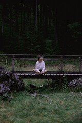 Mujer sentada en muelle cerca de las montañas