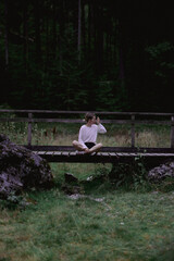 Mujer sentada en muelle cerca de las montañas