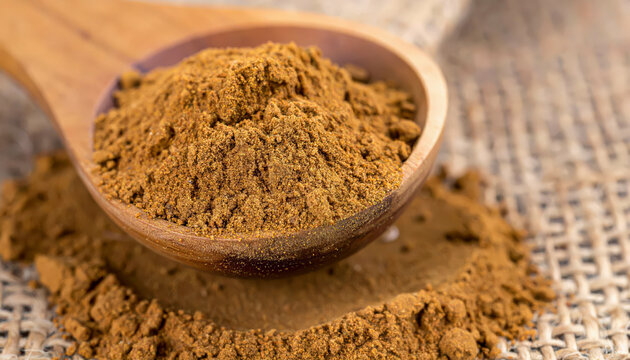 Aromatic ground cinnamon spice in a wooden spoon, a fragrant and healthy ingredient for cooking and baking