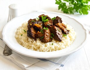Savory, browned liver pieces are artfully arranged atop a bed of fluffy white rice, creating a satisfying and visually appealing dish.
