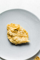 Overhead view of dublan northern nigerian snack, top view of dublan on a plate, flaky fried dough coated in syrup and sesame