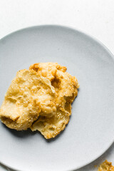 Overhead view of dublan northern nigerian snack, top view of dublan on a plate, flaky fried dough coated in syrup and sesame