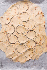 Overhead view of fire crackers dough cut out on parchment paper, top view of spicy cracker dough, process of making fire crackers