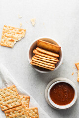 Overhead view of homemade crackers in a ramekin, top view of cracker biscuits on background