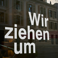 Schriftzug mit den Worten wir ziehen um, am Schaufenster eines Ladens in Deutschland