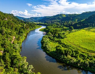 Fototapeta premium Serene river winding through lush green valley landscapes under a vibrant sky.