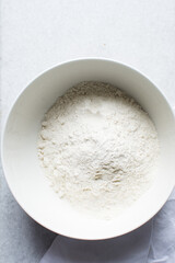 overhead view of All purpose flour in a bowl, top view of baking flour in a ceramic bowl
