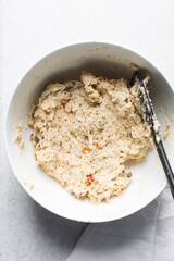 overhead view of savory biscotti dough in a bowl, top view of savory cookie dough in a mixing bowl