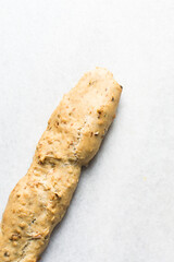 overhead view of bakery savory biscotti log on a parchment lined baking sheet, top view of savory cantucci cookie dough on parchment paper