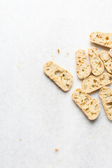 Overhead view of toasted bread chips on white background, top view of crostini bread on marble countertop