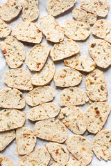 Overhead view of toasted bread chips on white background, top view of crostini bread on marble countertop