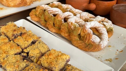 A luxurious hotel breakfast features an extensive selection of baked goods including croissants, bagels, muffins, pastries, breads, cookies, pancakes, waffles, scones, biscuits, donuts, rolls, Danish 