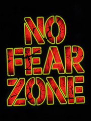 No Fear Zone sign red letters with cracks illuminated on black background