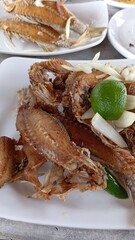 Fried fermented croaker fish with onion and lemon Ikan Bekok Gelama