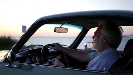 Senior man driving to beach enjoying the sunset by himself with his car