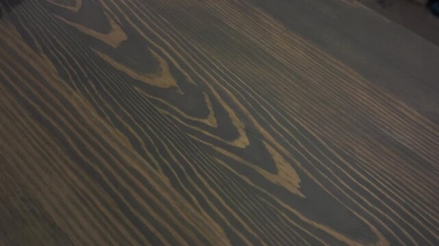 Craftsman's hands skillfully sanding wooden surface for smooth finish.