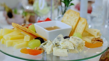 Artisan cheese board featuring gorgonzola, paired with crisp crackers, honey drizzle, fresh grapes, toasted walnuts, and dried apricots