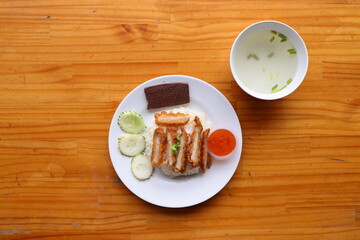 Chicken Rice Feast: This top-down culinary shot offers a vibrant display of chicken rice, a symphony of textures and tastes on a white plate, complemented by a bowl of clear broth and condiments.