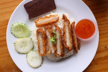 Crispy Pork Rice Delight: A top-down view showcases a plate of meticulously arranged crispy pork slices atop a bed of fluffy rice.