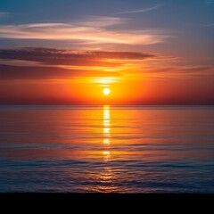 Fototapeta premium Stunning orange and red sunset mirroring vividly on a tranquil ocean surface, a serene view illustrating natural beauty and peace.