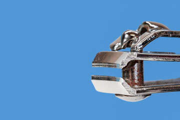 Close up view of Nail cutter isolated on blue background.