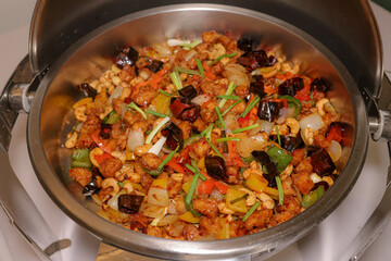 Kung Pao Chicken Dish: A tempting culinary creation features an array of chicken, vibrant bell peppers, spicy chilies, crunchy cashew nuts, and aromatic scallions.