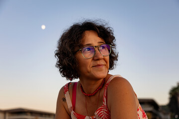 Portrait of a happy senior woman at the beach at sunset