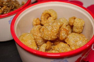 Crunchy Pork Rinds in a Bowl: Crispy, golden-brown pork rinds overflow from a decorated bowl, creating a close-up food image that highlights the texture, flavor, and appetizing appeal of the snack.