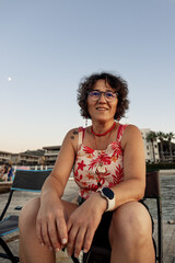 Portrait of a happy senior woman at the beach at sunset