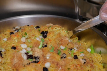 Delicious Pilaf: A close-up shot showcases the vibrant colors and enticing textures of a traditional pilaf, being served in a catering setting.